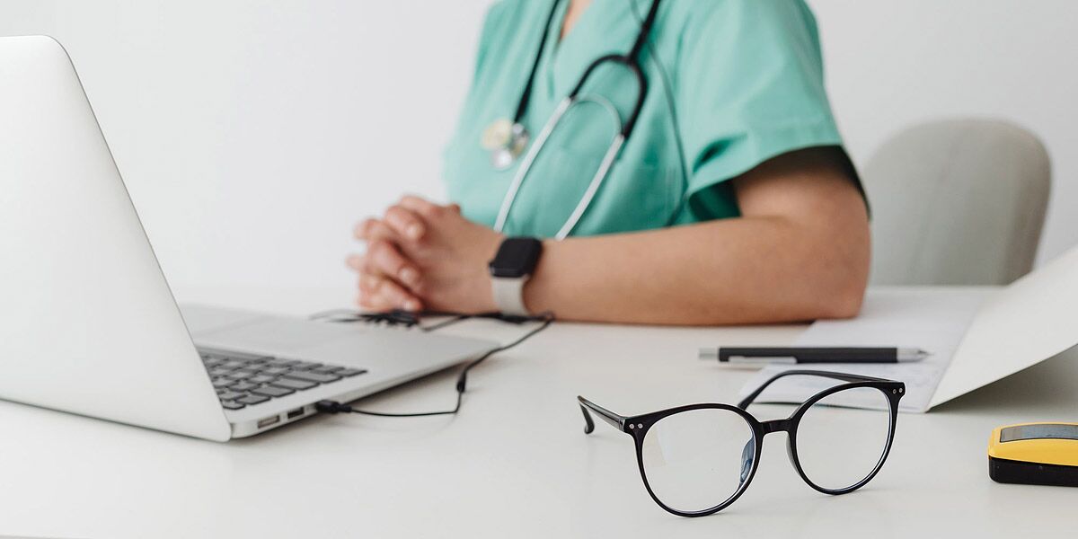Ärztin am Schreibtisch mit Laptop
